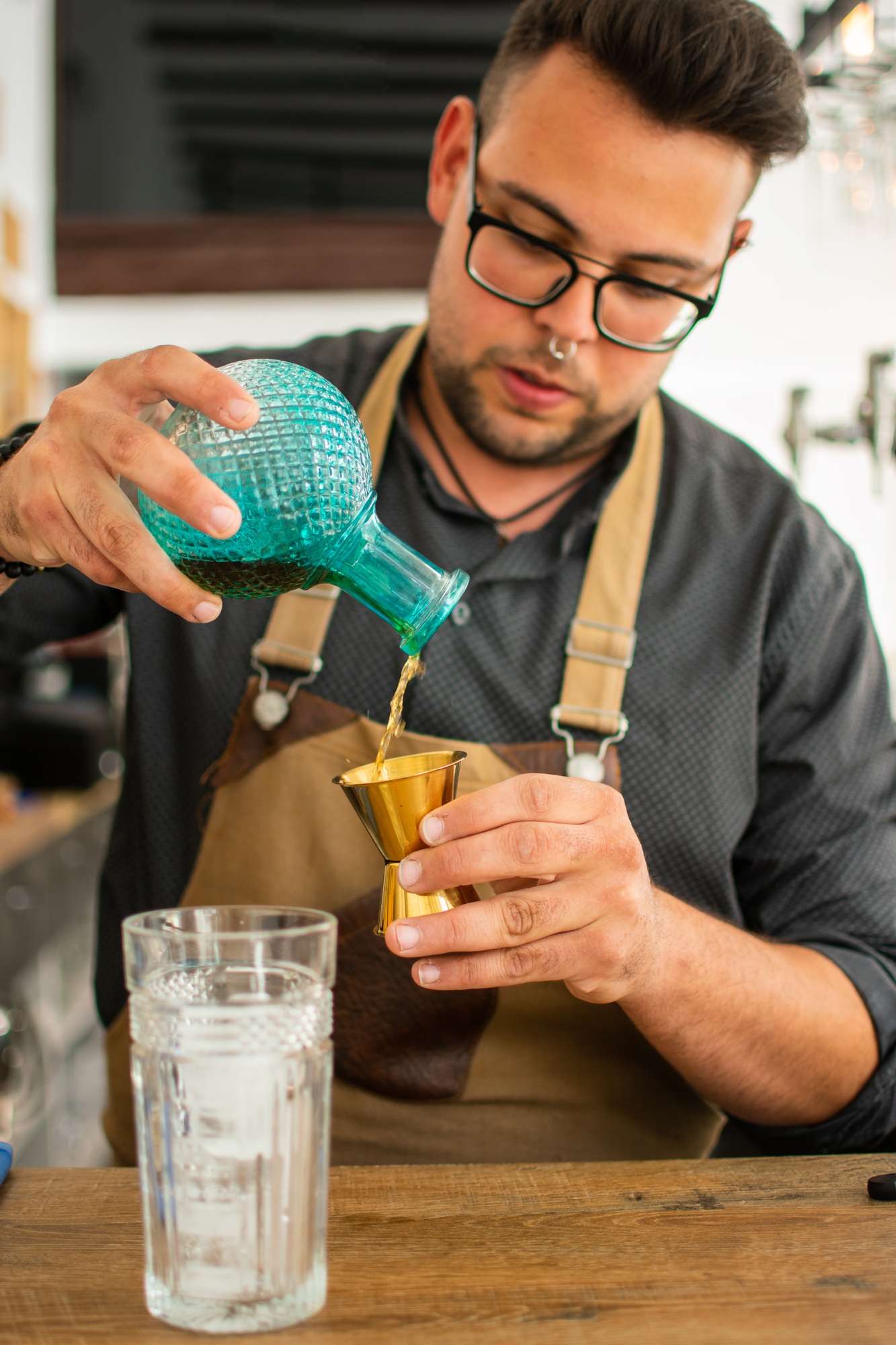 A bartender at a bar counter doing a cocktail